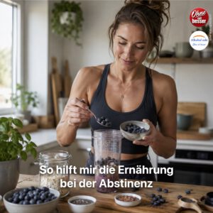 Frau bereitet in einer hellen Küche ein Frühstück aus Blaubeeren, Haferflocken und verschiedenen Samen in einem Mixbecher zu – als Symbol für eine bewusste Ernährung zur Unterstützung der Alkoholabstinenz.